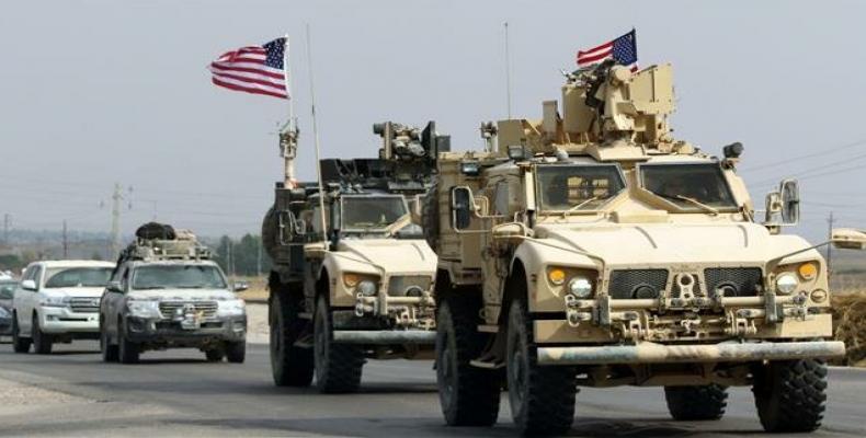 U.S. troops stand near military trucks at al-Omar oil field in Deir Al Zor.  (Photo: © Reuters / Rodi Said)