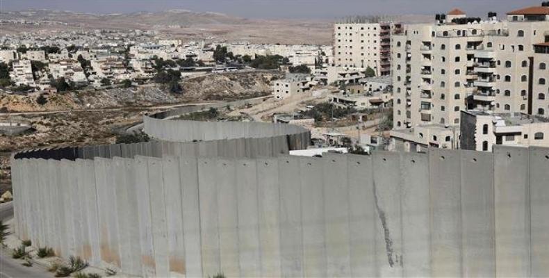This picture shows the Israeli settlement of Pisgat Ze'ev (L) behind its controversial separation barrier on the outskirts of East Jerusalem.  Photo: AFP