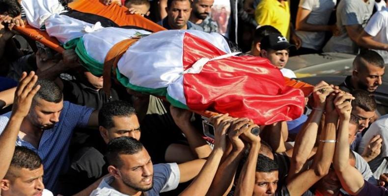 Palestinians carry the body of Dalia Ahmed Suleiman Samudi, killed by Israeli fire during clashes.  (Photo: AFP)