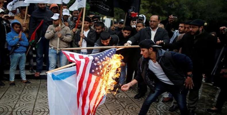 Palestinians burn an Israeli and a U.S. flag during a protest in Gaza City.  (Photo: Press TV)