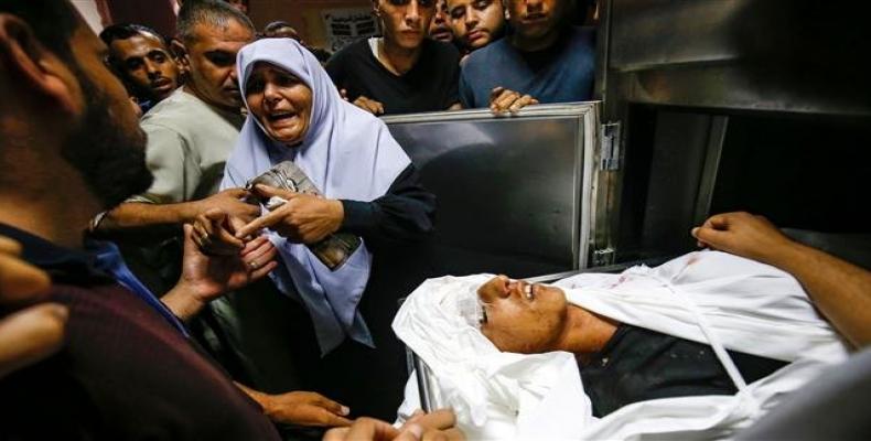 The aunt of slain 15-year-old Palestinian Ahmed Abu Habel killed during clashes with Israeli forces near a checkpoint in the northern Gaza Strip reacts by his b